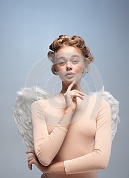 Close-up portrait of pretty, beautiful young girl, graceful ballerina in image of angel with wings isolated on white