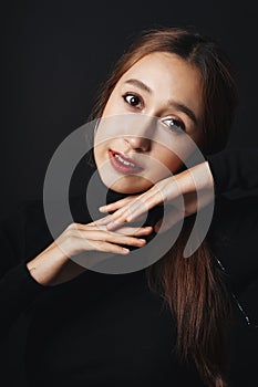 Close up portrait of pretty beautiful young woman wearing black sweater isolate over dark background