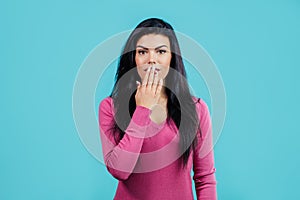 Close up portrait of pretty girl closing her mouth with hand