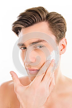 Close up portrait of pretty man smearing foam on his face