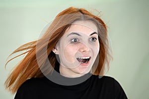 Close up portrait of pretty redhead girl with long wavy hair blowing on the wind