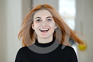 Close up portrait of pretty redhead girl with long wavy hair blowing on the wind