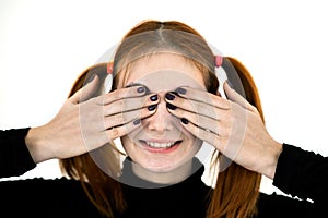 Close up portrait of pretty redhead teenage girl closing her eyes with hands