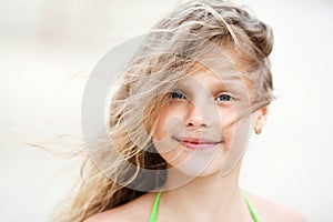 Close-up Portrait of a pretty smiling little girl with waving in