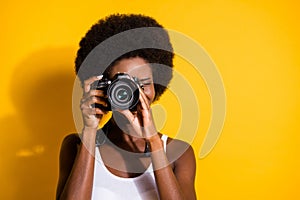 Close-up portrait of pretty wavy-haired brunette girl using digicam taking pictures snap isolated over bright yellow