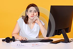 Close up portrait of pretty young female college student using desktop computer in a college library for writting report, has
