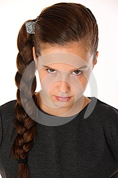 Close-up portrait of pretty young schoolgirl. She is serious and demanding