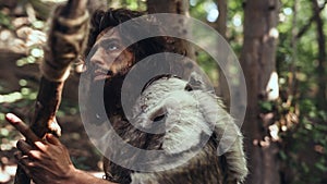 Close-up Portrait of Primeval Caveman Wearing Animal Skin and Fur Hunting with a Stone Tipped Spea