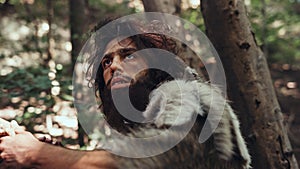 Close-up Portrait of Primeval Caveman Wearing Animal Skin and Fur Hunting with a Stone Tipped Spea