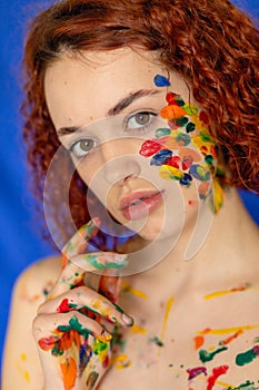 Close-up portrait of red curly haired woman Young cheerful soiled in paint