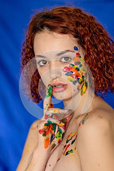 Close-up portrait of red curly haired woman Young cheerful soiled in paint