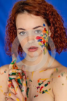 Close-up portrait of red curly haired woman Young cheerful soiled in paint