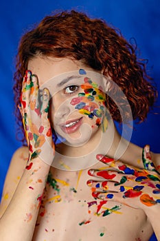 Close-up portrait of red curly haired woman Young cheerful soiled in paint