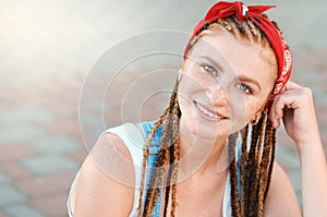 Close up portrait of red hair teenage girl with freckles in casual style in summer day on the street