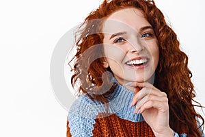 Close up portrait of redhead woman with curly natural healthy hair and pale smooth skin, touching clean and fresh face