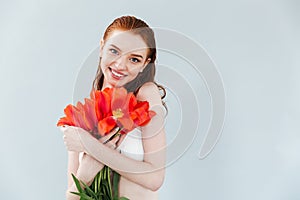 Close up portrait of a redheaded woman holding tulip flowers