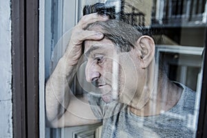 Close up portrait of sad and depressed 40s man looking through w