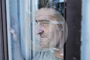 Close up portrait of sad and depressed 40s man looking through w