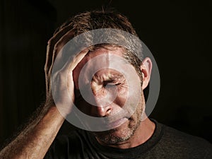 Close up portrait of sad and depressed man with hand on face looking desperate feeling frustrated and helpless crying miserable in