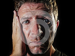 Close up portrait of sad and depressed man with hand on face looking desperate feeling frustrated and helpless in depression and s