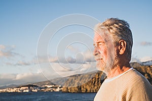 Close up and portrait of sad and pensive man looking at the sea in the beach - upset people lifestyle concept
