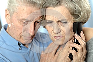 Portrait of sad senior couple portrait with phone