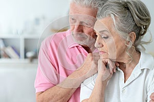 Close-up portrait of sad senior couple posing