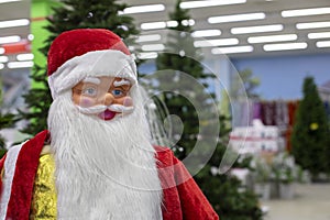 Close-up portrait of Santa Claus, toy santa with white beard on the background of the sale of trees