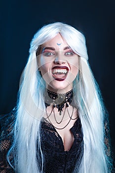 Close-up portrait of screaming vampire on black background