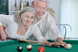 Close up portrait of senior couple playing billiard