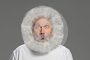 Close-up portrait of senior hairy grey-haired man isolated over grey background.