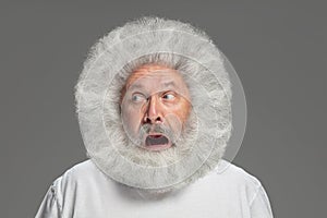 Close-up portrait of senior hairy grey-haired man isolated over grey background.