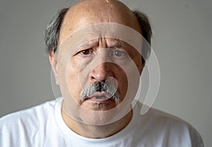 Portrait of disorientated and confused old man suffering from Alzheimer photo