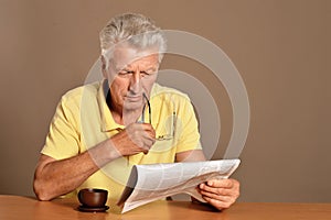 Close up portrait of senior man reading newspaper