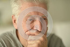 close-up portrait of a senior man thinking about something