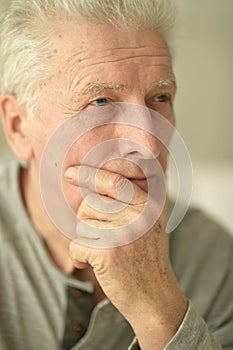 close-up portrait of a senior man thinking about something