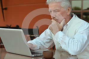 Close up portrait of senior man using laptop