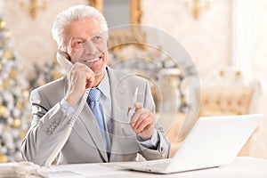 Close up portrait of senior man using laptop