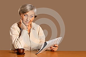 Close up portrait of senior woman reading newspaper