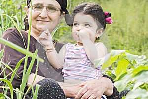 Close-up portrait of Senor Grandmother with her little grandchild at garden enjoying together photo