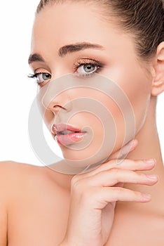 Close up portrait of sensitive young woman touching her chin