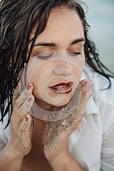 Close up portrait of sensual young woman with sand