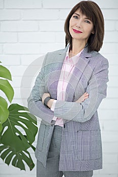 Close up portrait of a serious business woman in gray suit standing in the city