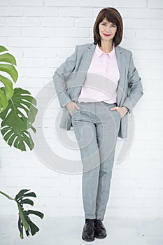 Close up portrait of a serious business woman in gray suit standing in the city