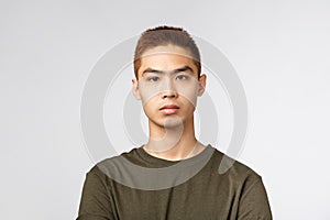 Close-up portrait of serious-looking japanese guy in green t-shirt, look serious and determined, listen to tutor during photo