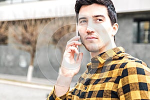 Close up portrait of a serious man with focused view speaking on the phone and looking away