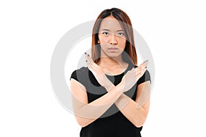 Close-up portrait of serious young asian lady showing stop gesture with crossed hands, looking at camera