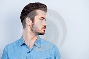 Close up portrait of serious young man looking at his left. He i