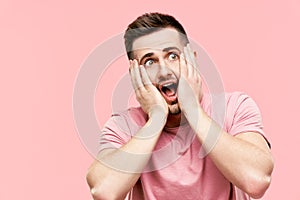 Close up portrait of shocked excited scared man with open mouth panicking over pink background