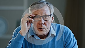 Close up portrait shocked old Caucasian businessman stressed upset man elderly 60s male worried holding head with shock